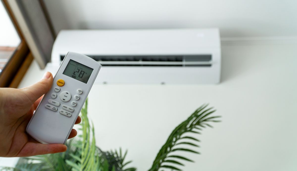 Individual,Adjusting,The,Air,Conditioning,With,A,Remote,Control,For