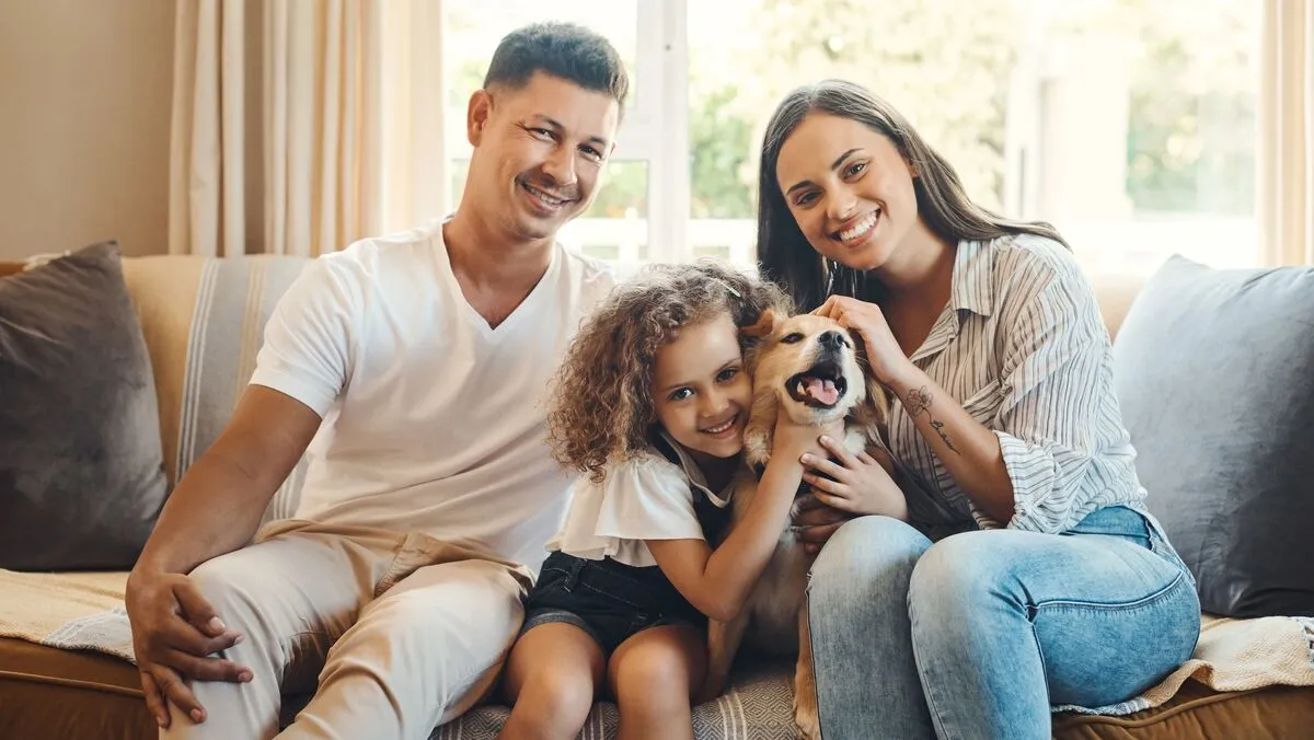 Mother,,Father,And,Girl,With,Dog,For,Portrait,On,Sofa családi adókedvezmény