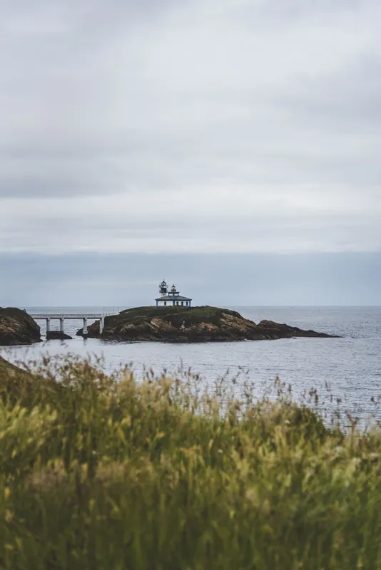 Isla Pancha island surrounded by the sea under a cloudy sky during daytime in Spain