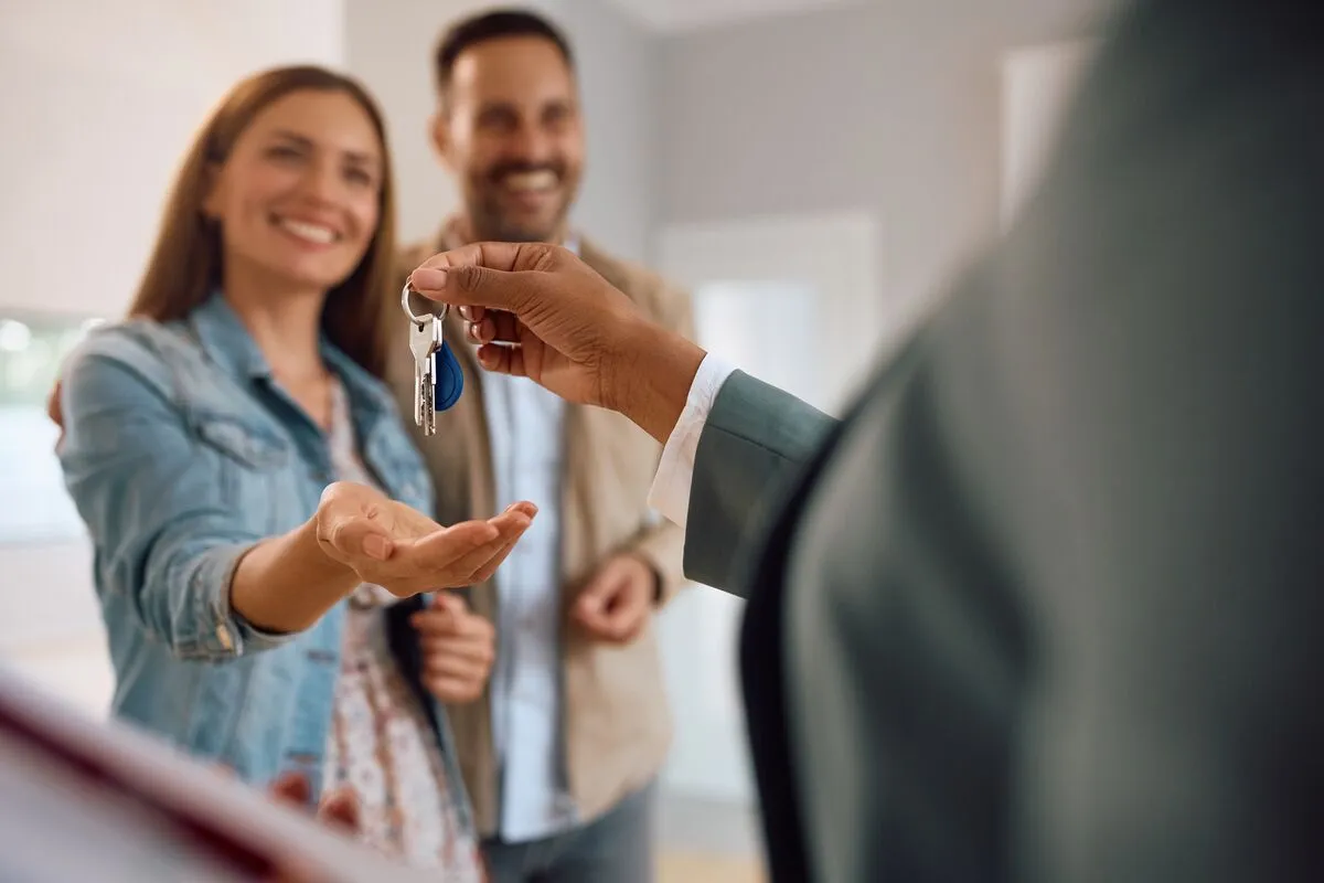 Close,Up,Of,Happy,Couple,Receiving,Keys,Of,Their,New