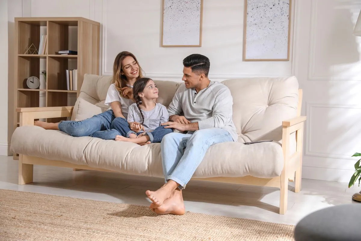 Happy,Family,With,Little,Daughter,Sitting,On,Sofa,In,Living