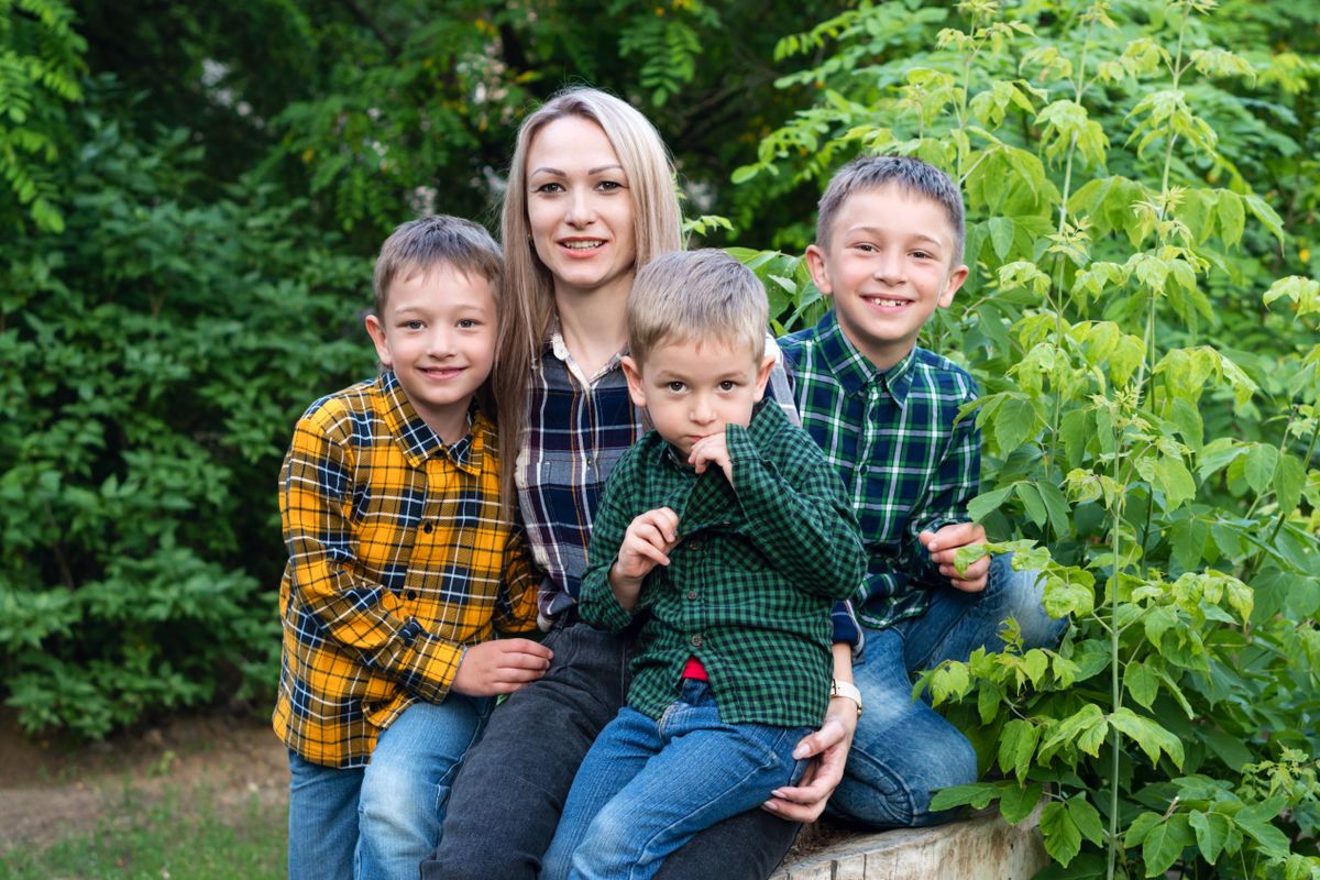 Single,Parent,Family,With,Three,Children,Sitting,On,Tree,Stumpand