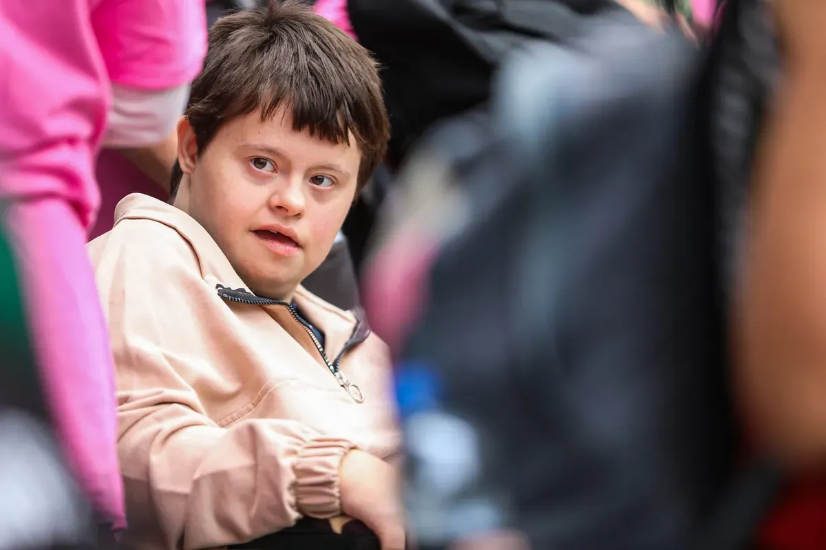 Egy Down-szindrómás fiatal a Sérült Gyermekek Napján, miközben felfedezi az állatkertet