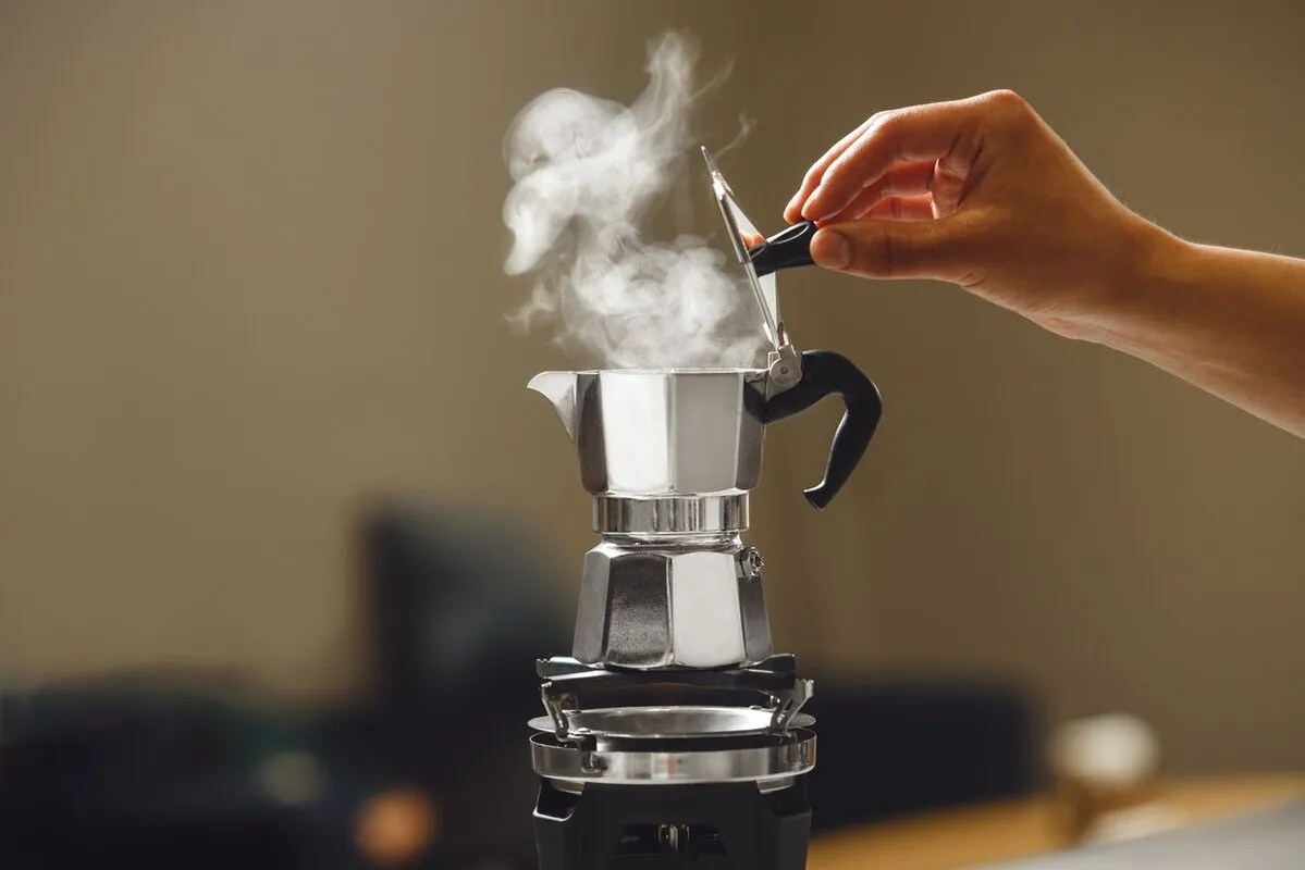 Kávét Hand,Closing,Lid,Of,Classic,Stovetop,Coffee,Maker,As,Steam