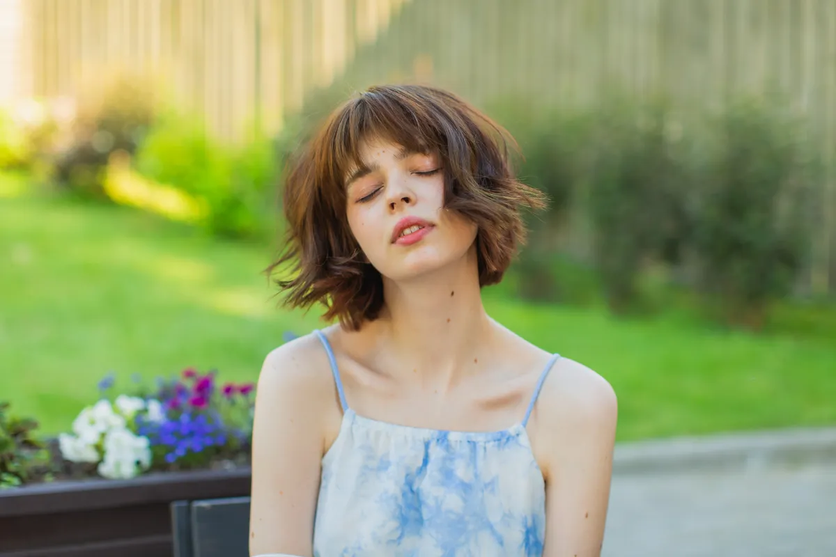 Beach bob frizura Young woman enjoying sunset.