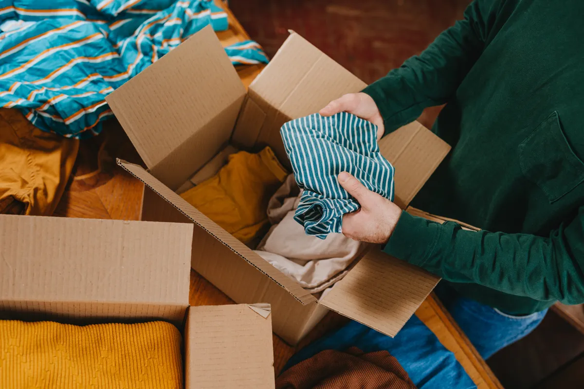 Csillagjegyek:beteges gyűjtögetők Unrecognizable,Man,Putting,Old,Out-of-use,Clothes,Into,Box,For,Charity