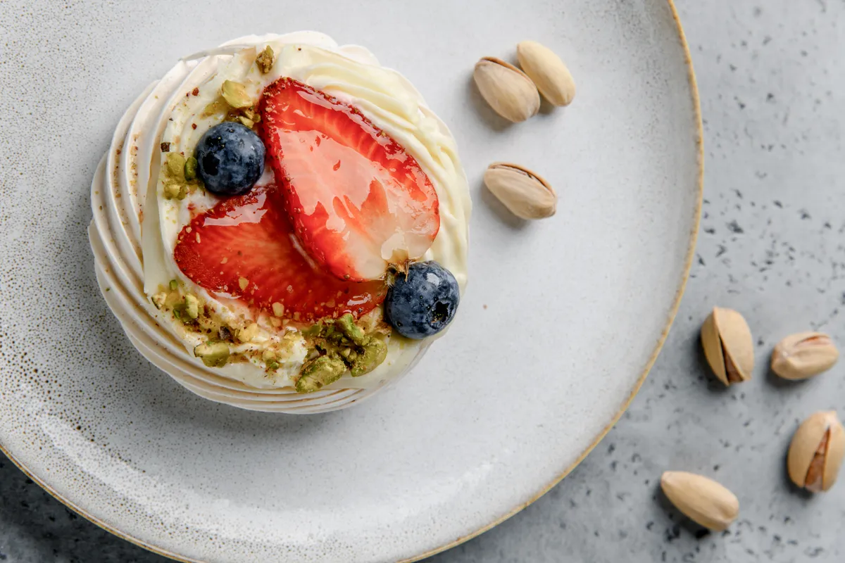 Húsvétra Pavlova mini torta Pavlova,Cake,With,Strawberries,,Blueberries,And,Pistachios,On,A,Light