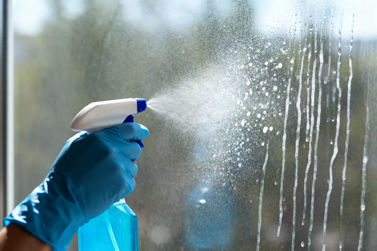 Ragyogni fog az ablak-A,Person,Is,Spraying,A,Window,With,Cleaning,Solution,,Getting
