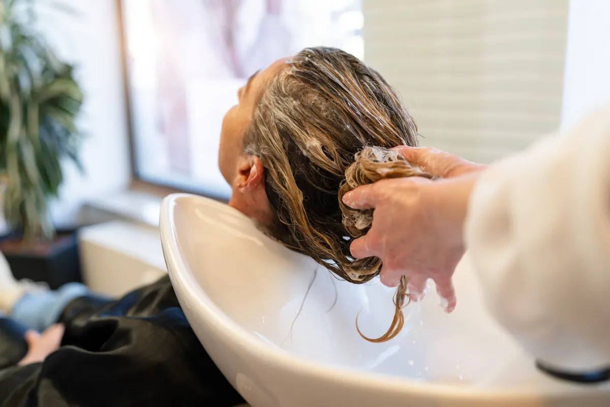 Hajmosás Hairdresser,Gently,Lathering,And,Shampooing,A,Woman's,Long,Hair,At