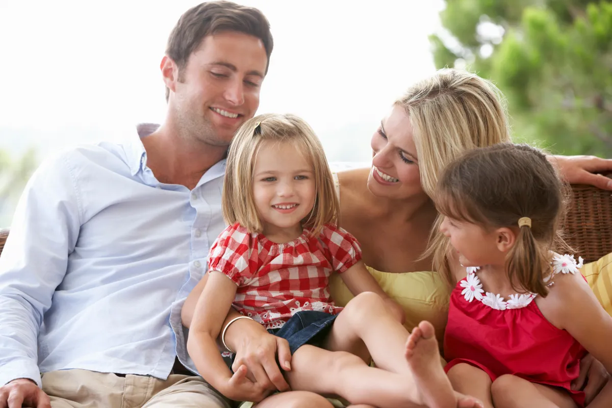 Family Sitting On Garden Seat Together