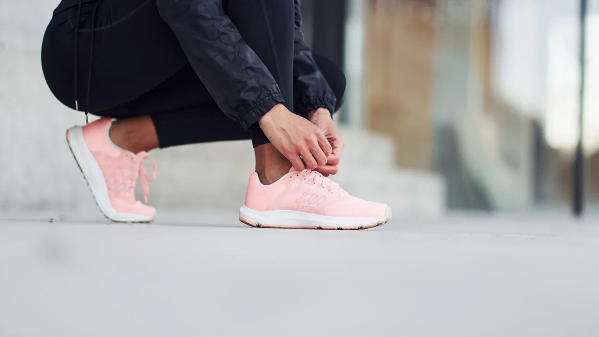Close up view of woman that sitting and wearing shoes outdoors